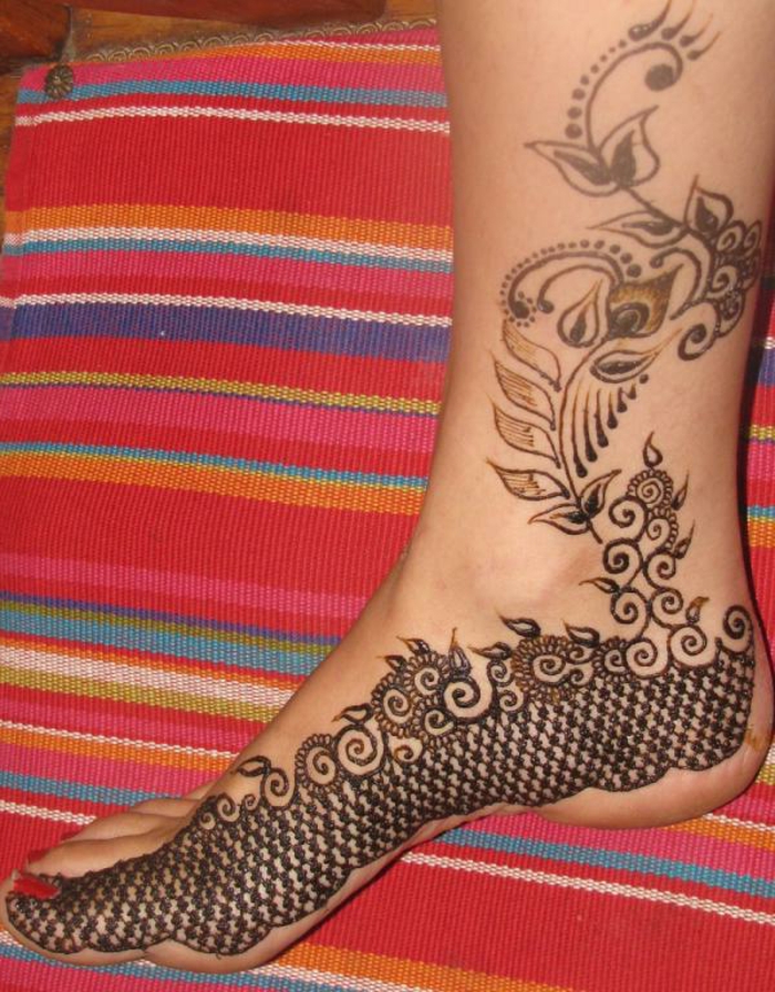 tatouage au henné, coussin ethnique et pied de femme avec dessins au henné