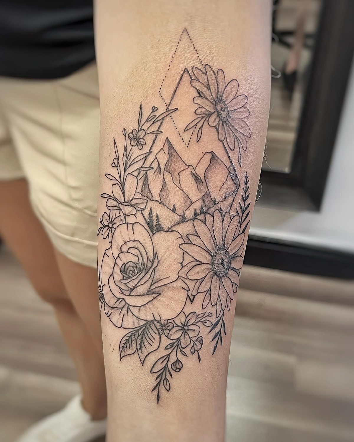 tatouage avant bras aux motifs fleuris avec triangles sommets
