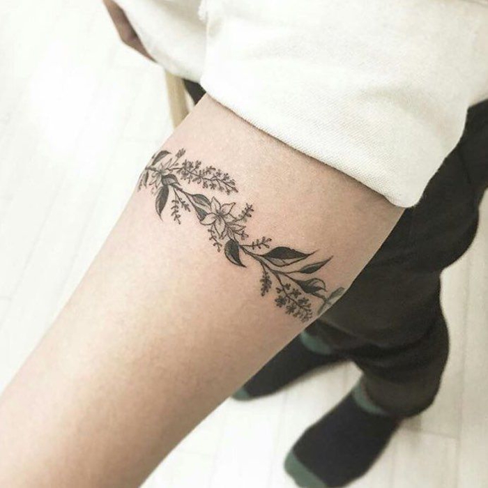 tatouage bracelet poignet en noir, une branche fleurie, idée de dessin graphique sur peau