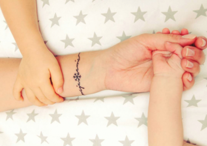 exemple de tatouage femme, tatouage lettres, les prénoms d enfants et un flacon de neige, idée de tatouage bracelet personnalisé mère