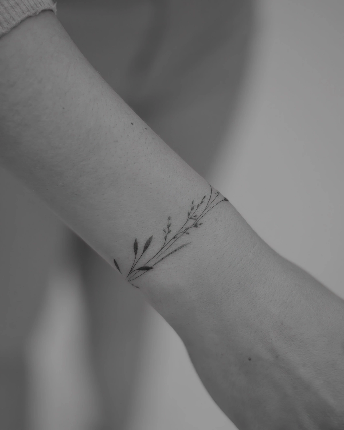 tatouage bracelet fleur photo blanc noir tige feuilles branche main femme