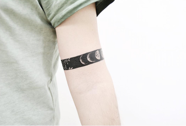 tatouage bracelet homme, bande noire, dessin des planètes du système solaire, design tatouage simple et inéressant
