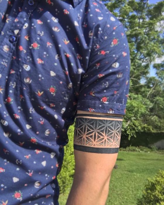 exemple de tatouage bracelet homme, une bande noire à motifs floraux, fleurs simples, tatouage armband