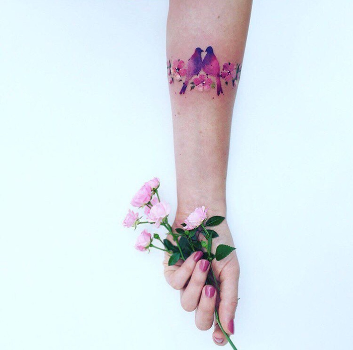 tatouage femme, une branche fleurie, fleurs rose et oiseaux en rose et mauve, idée de tatouage bracelet élégante