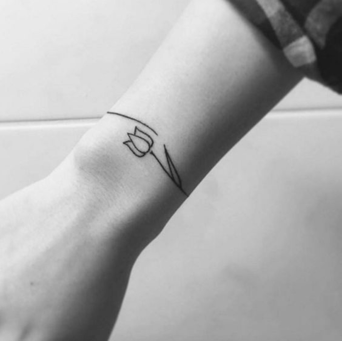 tatouage femme, bracelet au poignet, une tulipe, dessin noir graphique, idee tattooo fleur