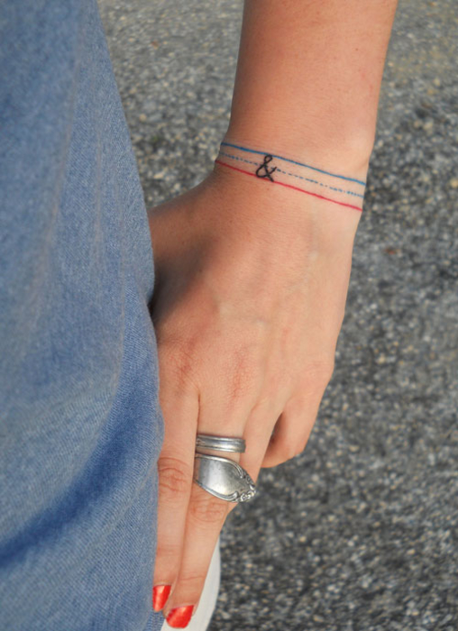 tatouage femme, bracelet à fils bleus et rouge, signe and, idée de tatouage poignet discret