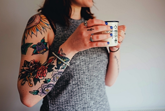idée de tatouage bras complet à motifs floraux colorés combiné avec un petit tatouage clef de sol, tattoo tournesol à l'épaule
