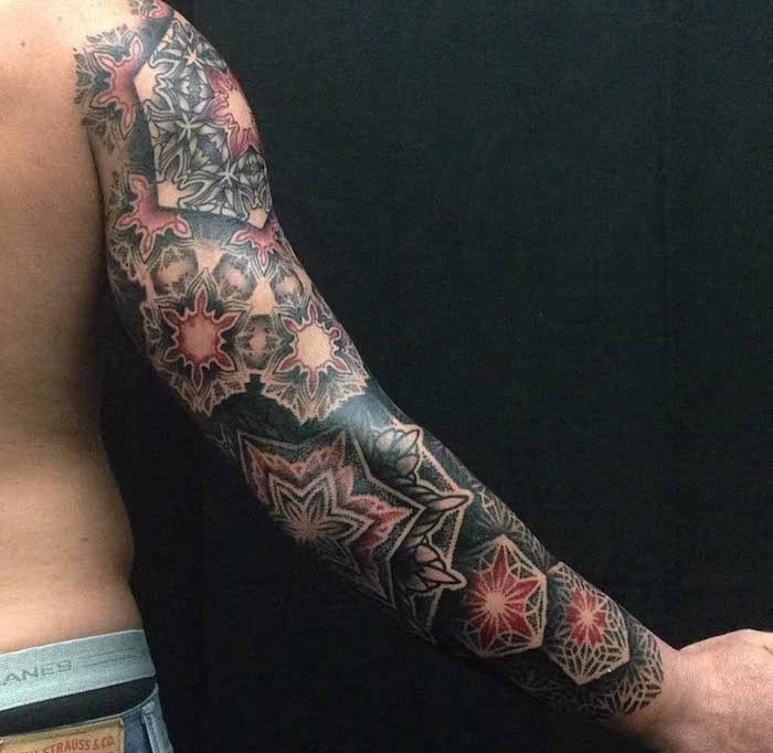 tatouage sur tout le bras homme noir rouge rosaces mandalas