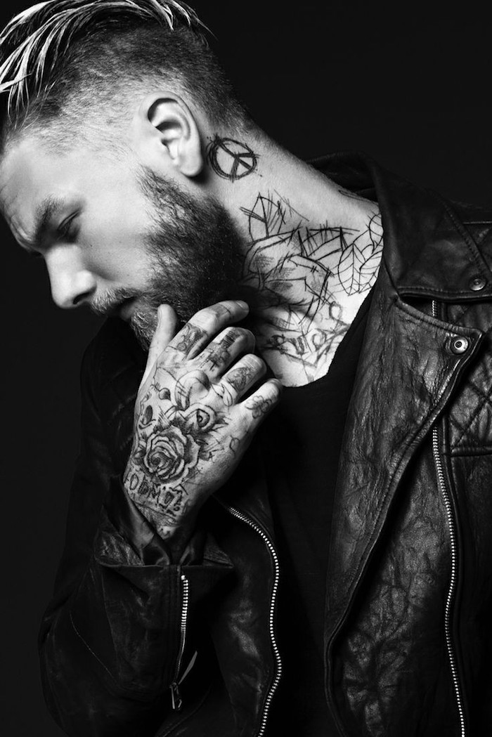 tatouage bras homme, barbe noire, coiffure rasé sur le côté, tatouage sur le cou, veste en cuir noir homme