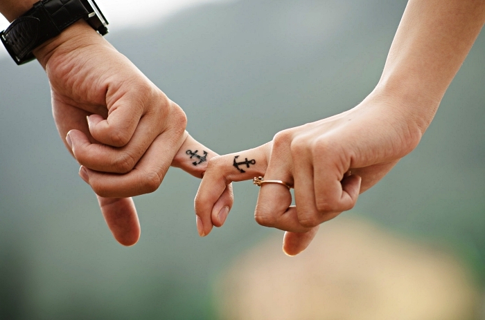 tatouage de couple minimaliste petite ancre sur le doigt majeur, tatouage simple pour couples d'amoureux