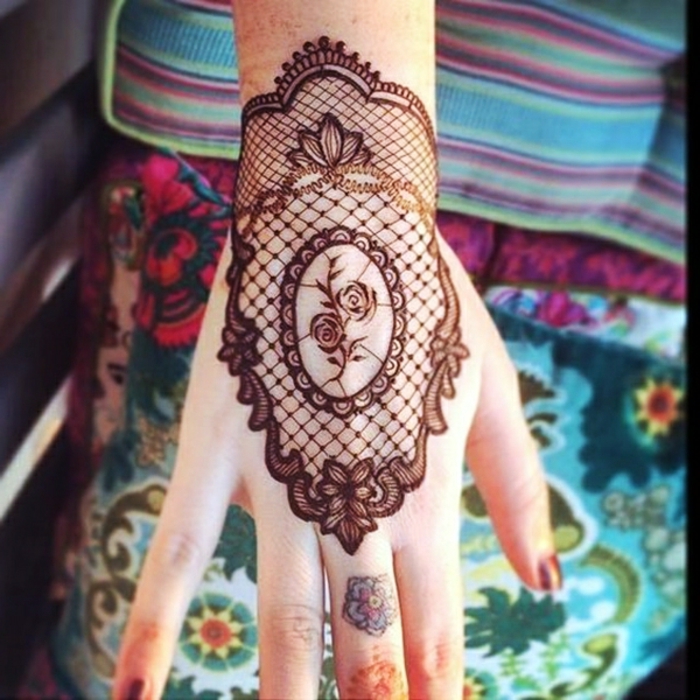 tatouage dentelle, mandala au poignet, petites roses au centre de l'image, motifs ornementaux