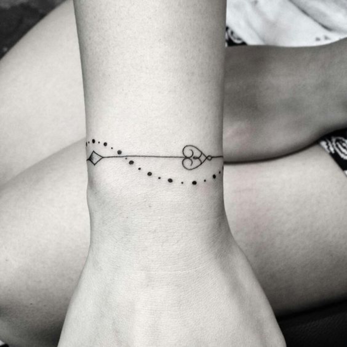 idée de tatouage bracelet poignet, chapelet de petites perles, fil noir avec autres éléments décoratifs, un accent en coeur