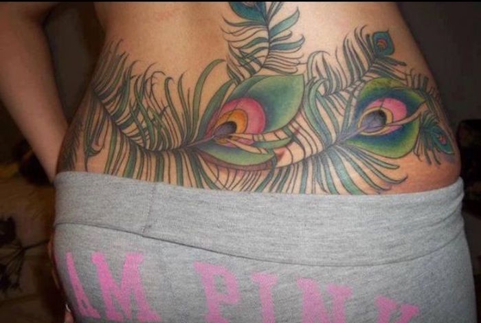 tatouage femme bas du dos plume de paon couleurs