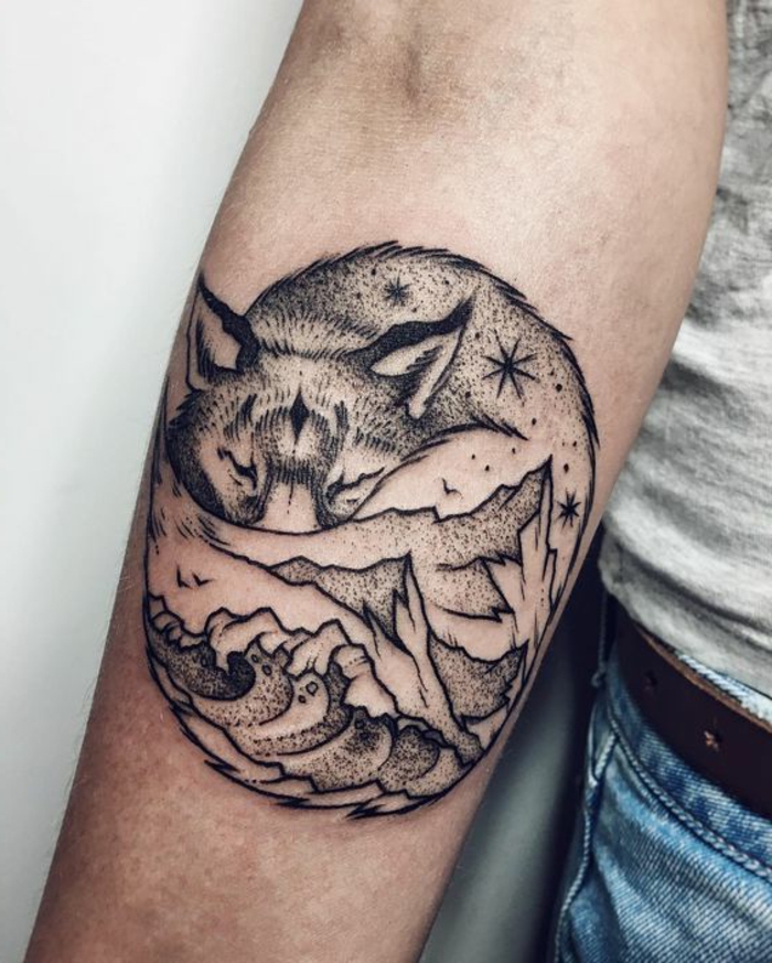 tatouage mignon, loup qui dort et montagne mystique sous la coude, tatouages noirs et blancs