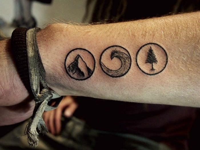 tatouage minimaliste homme, trois symbole de nature tatoués sur le bras