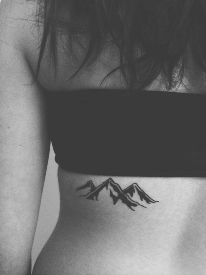 tatouage noir et blanc sur le dos d'une fille, dessin symbolique de montagne