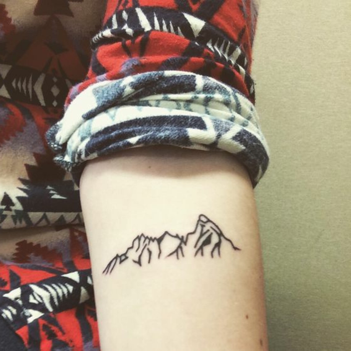tatouage noir et blanc, montagne sous le bras, chemise multicolore
