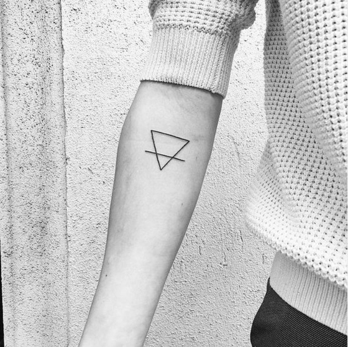 tatouage petit avant bras géométrique, une triangle et une ligne noire graphique qui passe à travers