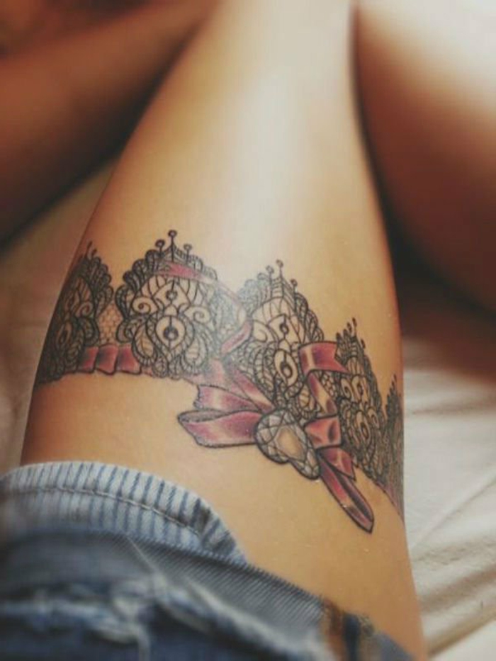 tattoo dentelle, motifs noirs, tour de jambe dentellé avec ruban rouge tatouée