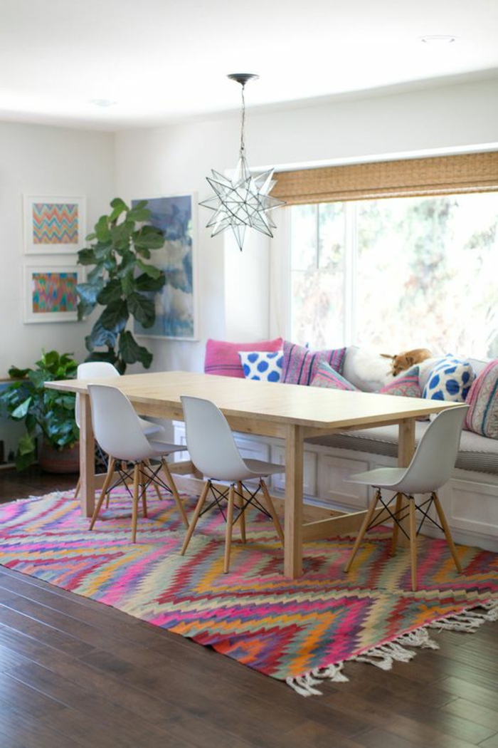 tissus ethniques, tapis géométrique, grande table en bois clair, chaises scandinaves