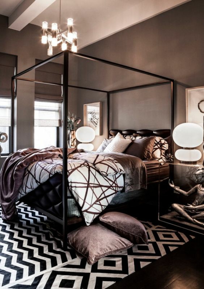 chambre design tapis noir et blanc motifs géométriques coussins et couverture couleur prune