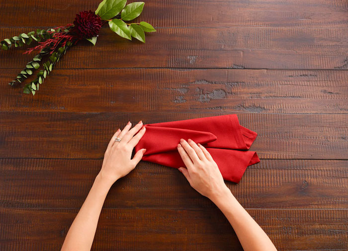 nappe de table, guide avec images pour apprendre à plier une serviette rouge