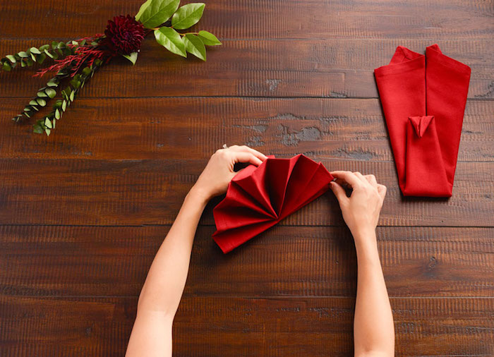 diy deco de table de noel, technique origami avec nappe de table rouge, activité manuelle pour femme
