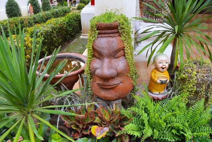 amenagement jardin zen, statues japonaises, une fontaine d eau, buis, arbustes et palmier, idee deco exterieur exotique