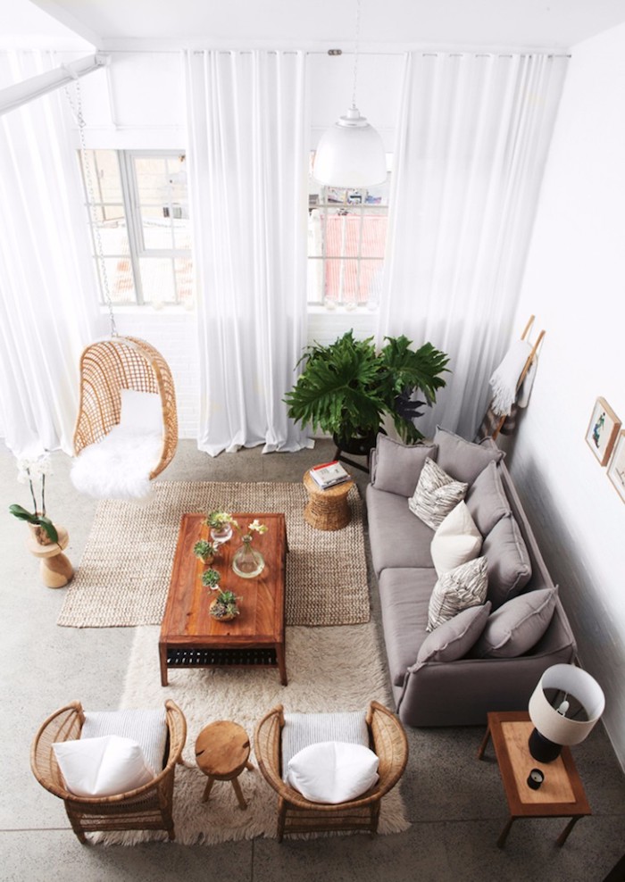 meuble scandinave, chaise suspendue en fibres végétales, canapé gris, plantes vertes, rideaux longs en blanc