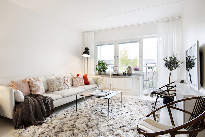 deco scandinave, chaise ronde, canapé blanc en cuir, tapis blanc et marron, rideaux longs, lampe sur pied noire