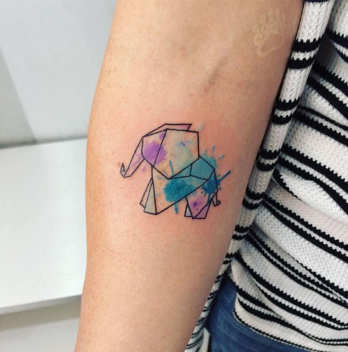 un délicat tatouage aquarelle à forme géométrique représentant un éléphanteau origami