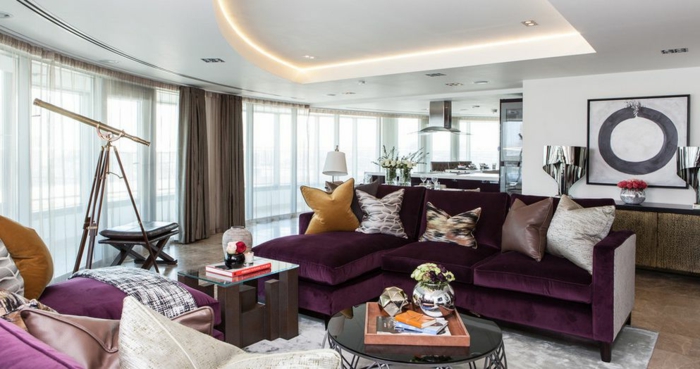 aubergine couleur, salon contemporain, faux plafond lumineux, plusieurs grands coussins, canapé d'angle pourpre