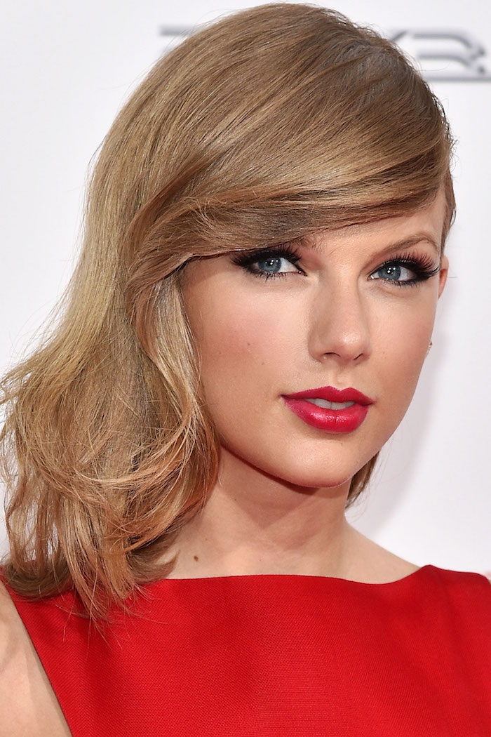 couleur de cheveux tendance, coiffure célébrité, Taylor Swift, cheveux mi longs avec frange de côté, rouge à lèvre et robe rouge
