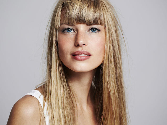 cheveux blond foncé, visage avec tâches de rousseur, coiffure cheveux lisses avec frange, yeux bleu et eye-liner noir