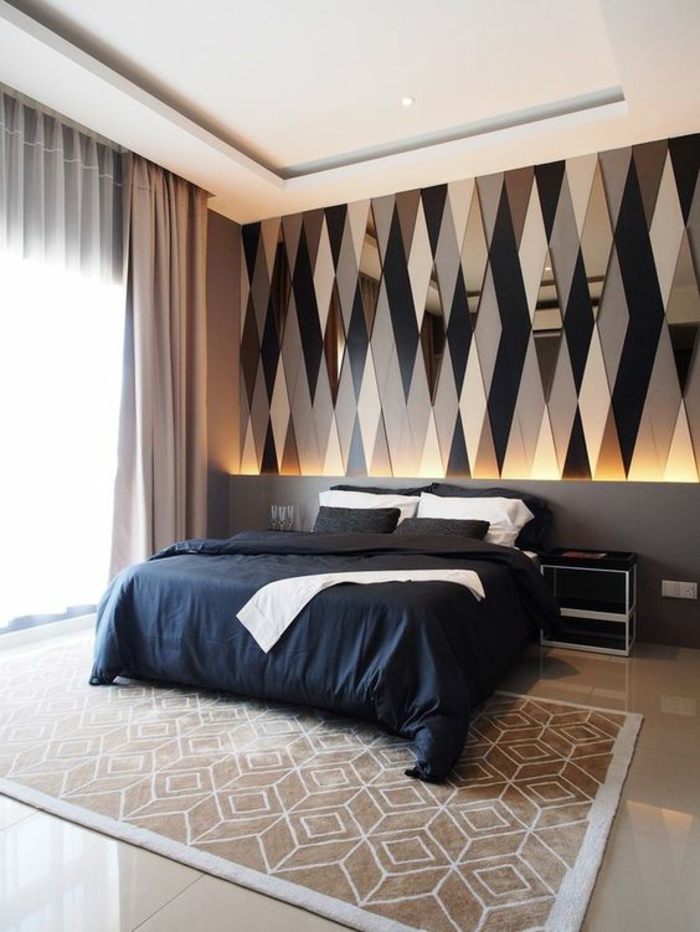 chambre design lit avec couverture et coussins bleus et murs aux miroirs triangles décoratifs