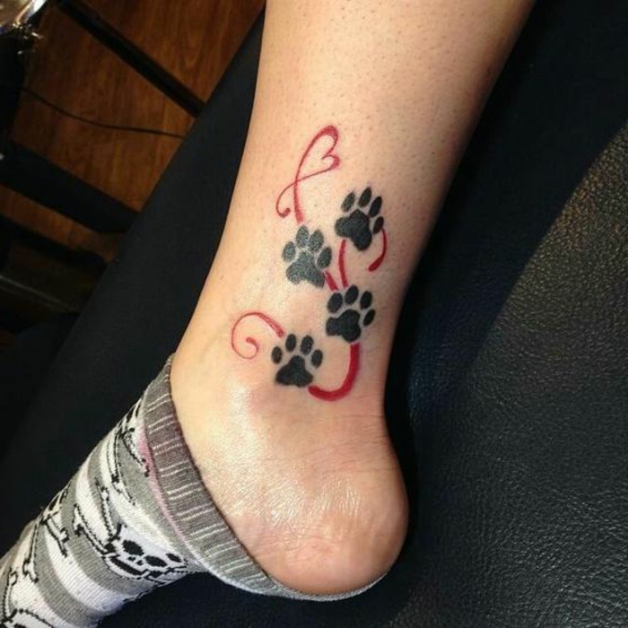 chat tatouage, trace d'empreintes de chat noires tatouées au-dessus de la cheville