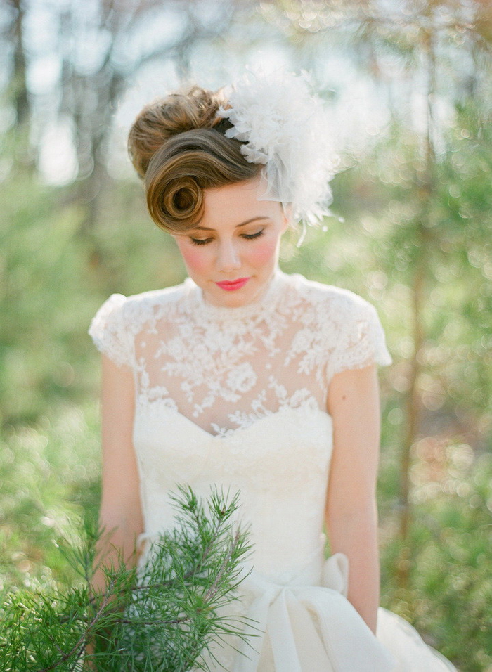 une coiffure de mariée romantique d esprit vintage, chignon rétro avec frange torsadé enjolivé par un joli accessoire en tulle