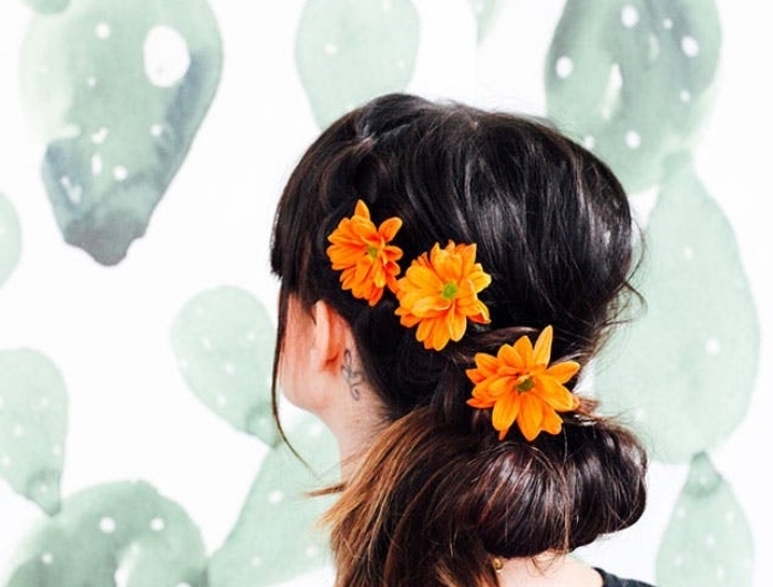chignon bas facile a faire, décoré de trois fleurs orange, idée de coiffure féminine mariage, occasion spéciale, style boheme, champetre chic