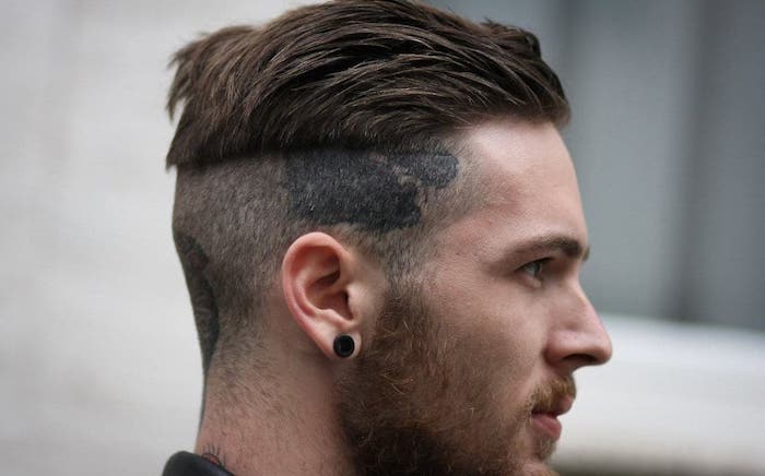 coupe de cheveux homme court, piercing oreille en noir pour homme, undercut avec tatouage sur la tête
