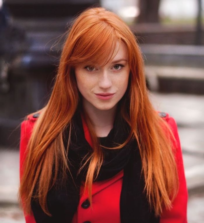 couleur cheveux cuivré, yeux gris et lèvres rose, coiffure orange avec frange, manteau rouge pour femme