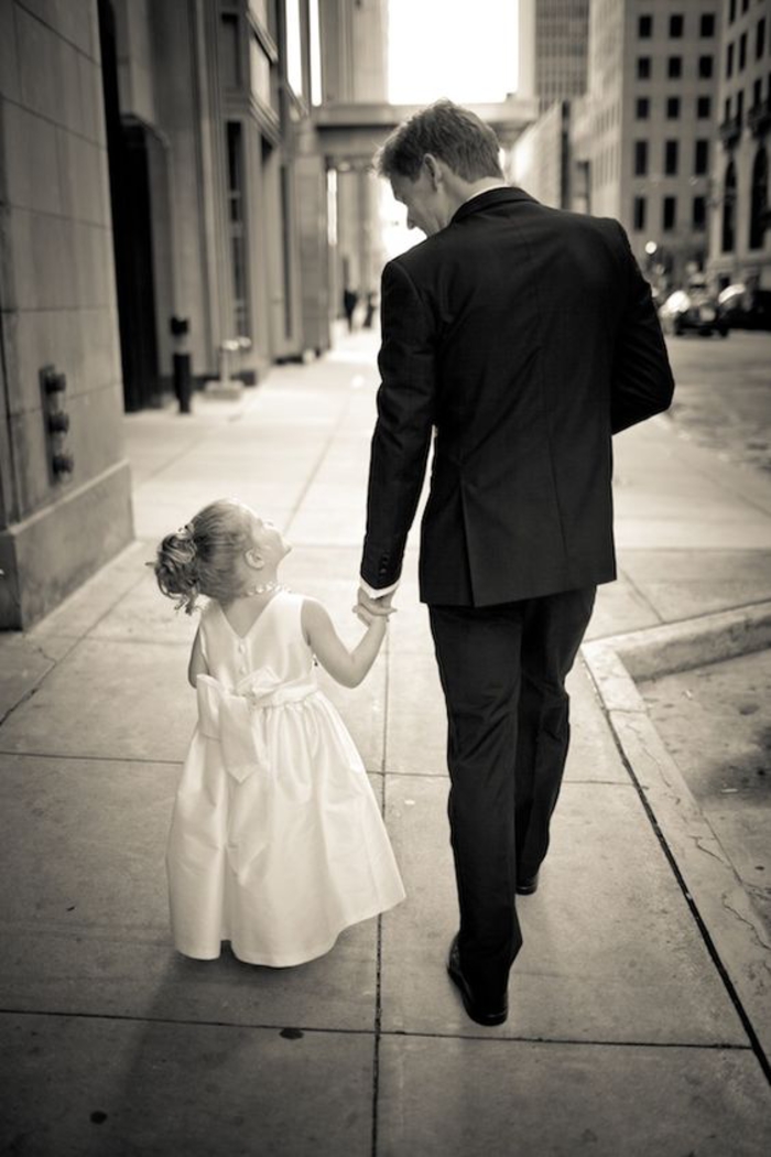 une adorable photo mariage en noir et blanc d'une petite fille d'honneur accompagné de marié