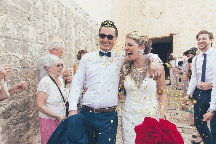 photo de couple heureux sous une pluie de confettis, photo mariage à la sortie de l église