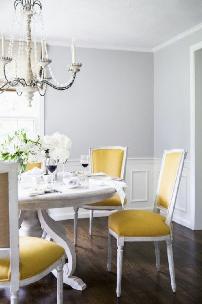 gris perle dans une salle a manger avec un grand lustre classique baroque et des chaises en jaune et blanc 