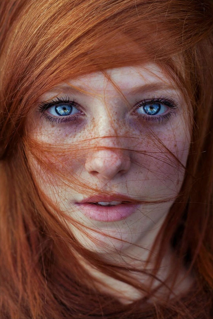 blond cuivré, visage féminin aux yeux bleus, rouge à lèvres nuance rose, coiffure cheveux raids et orange