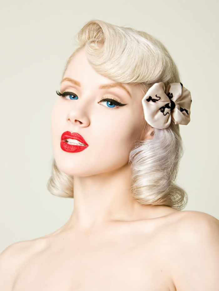 un maquillage pin up des années 50 et des cheveux blond platine façonnés en boucles vintage