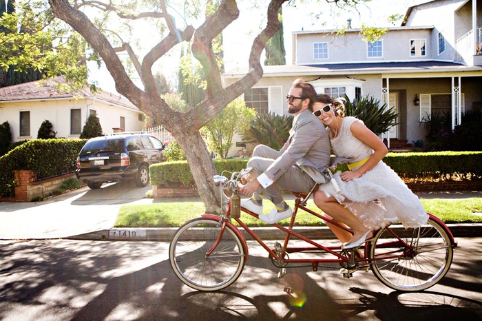 cliché de couple original, photo mariage décontractée et toute naturelle des mariés sur vélo