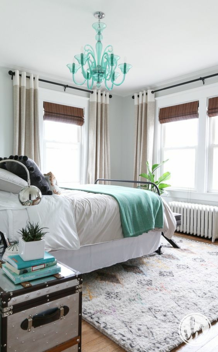 deco chambre classique en gris perle et blanc, couverture de lit et lustre couleur vert mint, tapis blanc à motifs géométriques, table de nuit en coffre