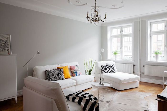 inspiration scandinave, plafond blanc avec décoration en plâtre, canapé blanc avec coussins décoratifs