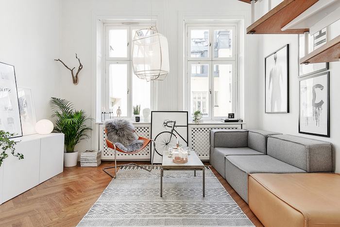 appartement scandinave, tapis en blanc et gris à motifs triangulaires, chaise orange avec housse en faux fur, cornes en bois