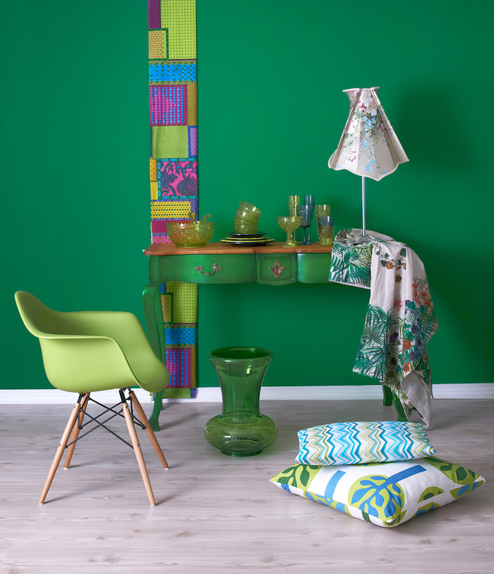 motif tribal, vase en verre verte, coussins décoratifs à motifs tropicales, meuble vintage en bois peint en vert, chaise verte avec pieds en bois